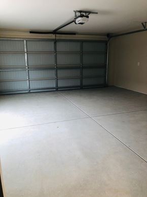 Dodge City apartment for rent - A spacious garage with a closed grey door.