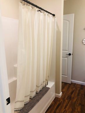 Dodge City apartment for rent - A white shower curtain hanging in a bathroom.