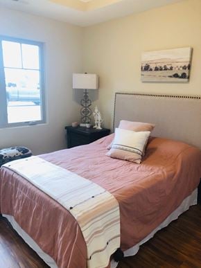 Dodge City apartment for rent - A bed with a pink comforter and a white pillow is in the room.
