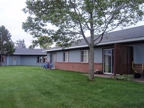 Sault Ste Marie apartment for rent - a yard in front of a blue house with a tree