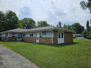 Youngstown house for rent - a white and brick house with a lawn and trees