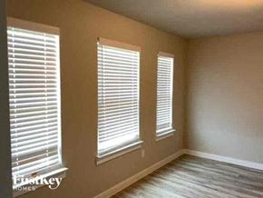 Lewisville house for rent - a living room with three windows with white blinds