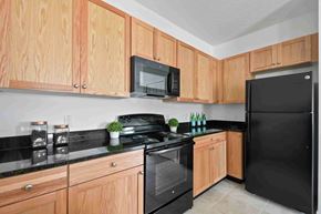 Casselberry apartment for rent - A kitchen with wooden cabinets and black appliances.