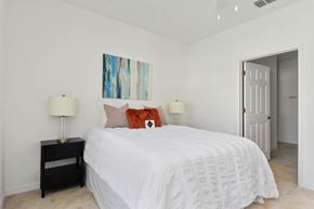 Casselberry apartment for rent - A bedroom with a white bed and a painting on the wall.