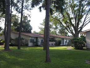 Casselberry apartment for rent - A house with a green lawn and trees in front.