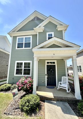 Greenville house for rent - a green house with a white rocking chair in front of it