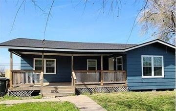 Corpus Christi house for rent - A blue house with a porch and a trash can.