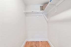 Newark apartment for rent - A white room with a wooden floor and a white shelf with a pillow on it.