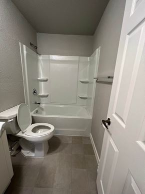 Dilworth apartment for rent - A white toilet is in a small bathroom with a white door.