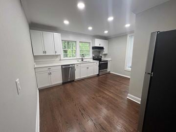 Rock Hill house for rent - a kitchen with white cabinets and a wooden floor