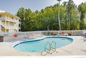 Orange Beach house for rent - the swimming pool is next to a building and a resort style pool