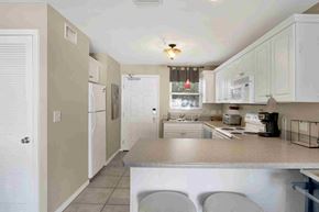 Orange Beach house for rent - a kitchen with white cabinets and a counter top
