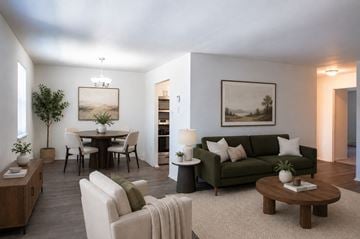 Camp Hill apartment for rent - A living room with a green couch, a coffee table, and a dining table with chairs.