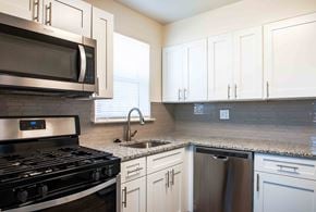 Camp Hill apartment for rent - A kitchen with a black stove top oven and white cabinets.