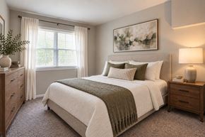 Reisterstown apartment for rent - A bedroom with a large bed, a nightstand, and a window with curtains.