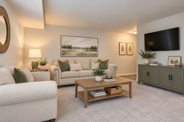 Reisterstown apartment for rent - A living room with a white couch, a wooden coffee table, and a painting on the wall.