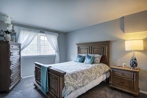 Reisterstown apartment for rent - a bedroom with a bed and a dresser and a window