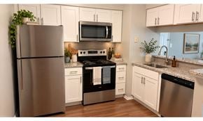 Owings Mills apartment for rent - A modern kitchen with a stainless steel refrigerator and a black oven.