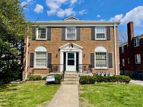 Louisville apartment for rent - A red brick house with a white door and black shutters.