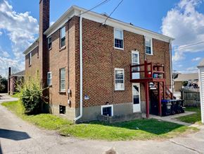 Louisville apartment for rent - A red brick house with a white window and a red door.
