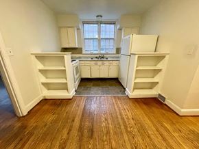 Louisville apartment for rent - A kitchen with white appliances and wooden floors.