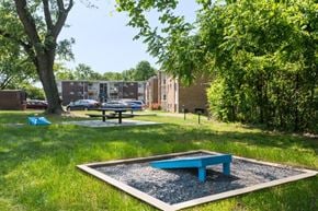 Glen Burnie apartment for rent - a picnic area with a blue bench in the grass
