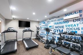 Glen Burnie apartment for rent - a gym with weights and a tv on the wall