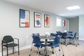 Glen Burnie apartment for rent - a dining room table with blue chairs and paintings on the wall