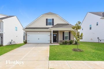 Greenville house for rent - a white house with a white garage door and a green lawn