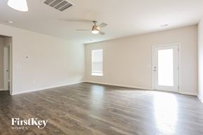 Greenville house for rent - an empty living room with wood floors and a ceiling fan