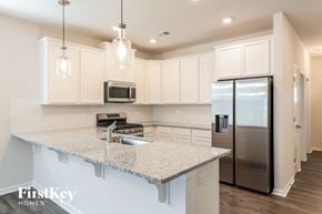 Greenville house for rent - a kitchen with white cabinets and a granite counter top