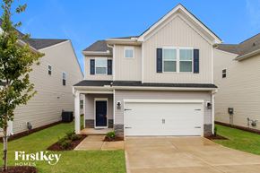 Simpsonville house for rent - a beige and white house with a garage door and a lawn