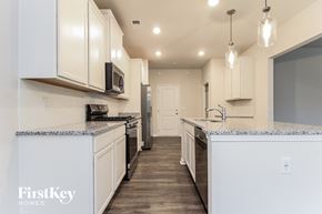 Simpsonville house for rent - a kitchen with white cabinets and a counter top and a sink