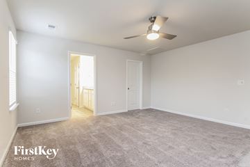 Simpsonville house for rent - a spacious living room with carpet and a ceiling fan