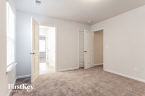 Simpsonville house for rent - a master bedroom with a carpeted floor and doors to two closets