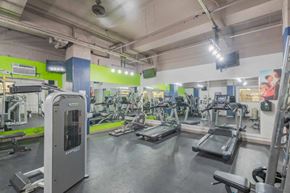 Baltimore apartment for rent - a gym with cardio equipment and weights in a building with green walls