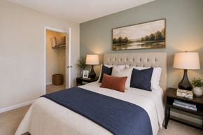 Laurel apartment for rent - A bedroom with a large bed and a painting on the wall.