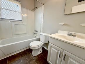 Louisville apartment for rent - A white bathroom with a toilet, sink, and tub.