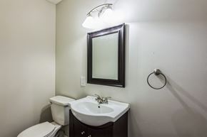 Louisville house for rent - A bathroom with a toilet, sink and mirror.