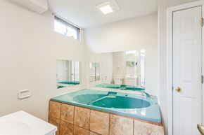 Louisville house for rent - A bathroom with a blue bathtub and a white toilet.