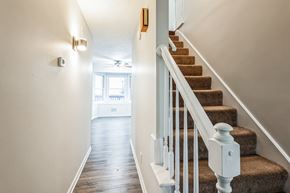 Louisville house for rent - A staircase with a white railing and a brown carpet.