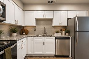Omaha apartment for rent - A kitchen with white cabinets and a black refrigerator.