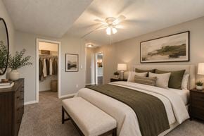 Omaha apartment for rent - A bedroom with a large bed and a painting on the wall.