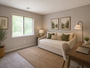 Spartanburg apartment for rent - A cozy bedroom with a bed, a desk, and a potted plant.