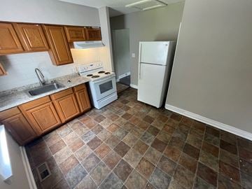 Louisville apartment for rent - A kitchen with brown cabinets and a white stove top oven.
