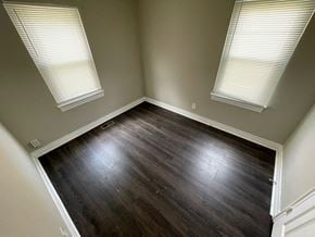 Louisville apartment for rent - A room with wooden floors and two windows.
