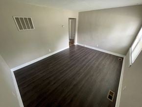 Louisville apartment for rent - A room with wooden flooring and a door on the right side.