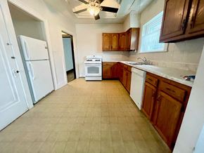 Louisville apartment for rent - an empty kitchen with white appliances and wooden cabinets