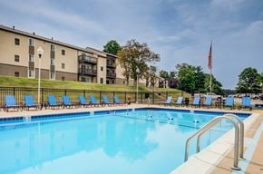 South Park apartment for rent - A swimming pool with blue water and a row of blue lounge chairs.
