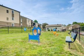 South Park apartment for rent - A playground with a blue slide and a bench in front of apartment buildings.